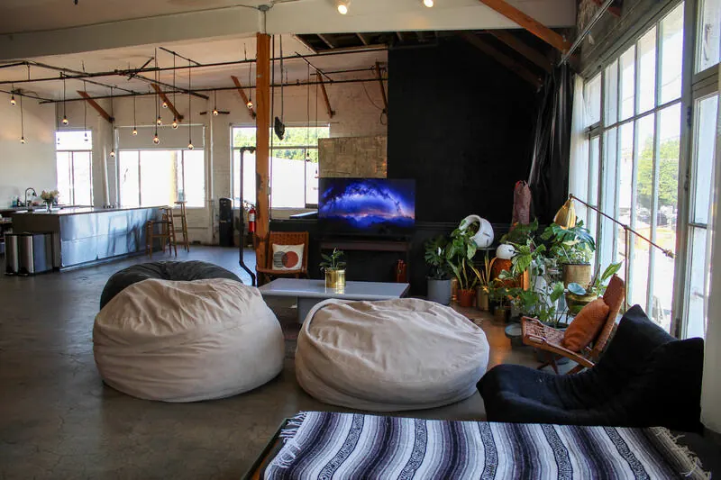 A lounge corner of the Loft with bean bags, plants and a screen