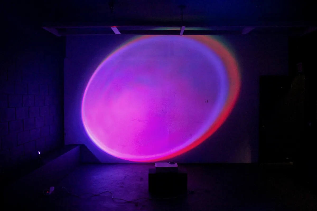 Studio B at night, a large glowing projection on the back wall