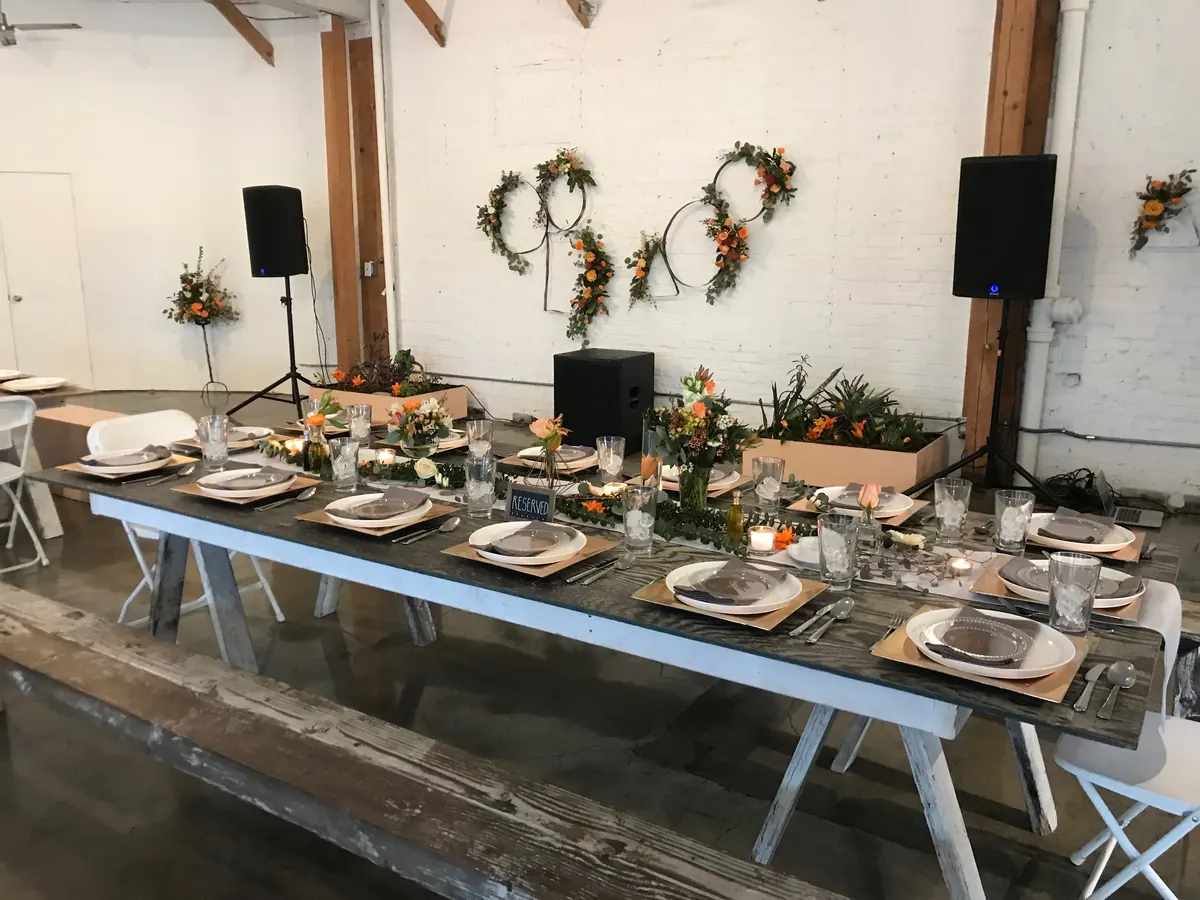 A table set with plates, glasses and flowers in the Loft in daylight