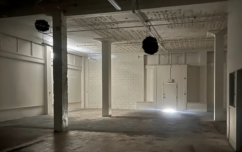 Columns and a cinder block wall under work lights
