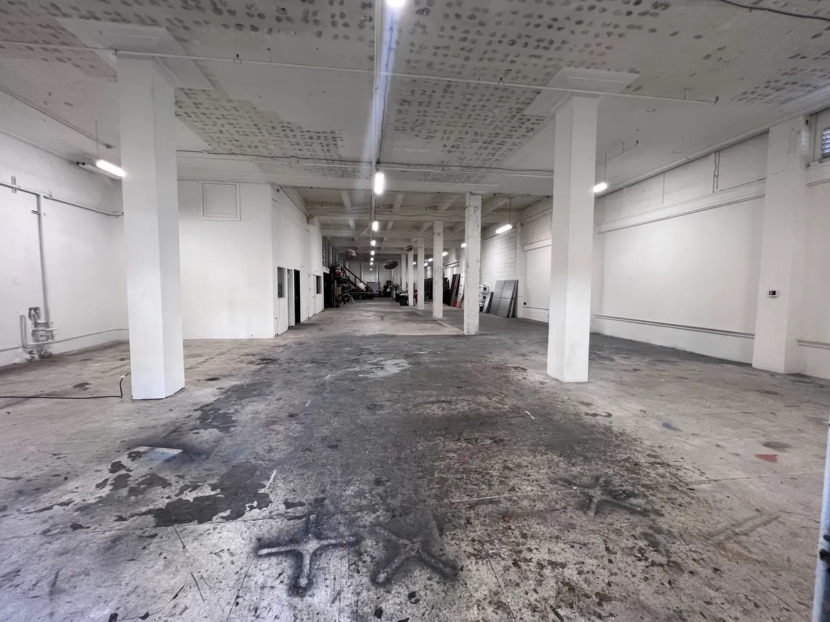 Looking down the length of the ground floor, white columns and a concrete floor